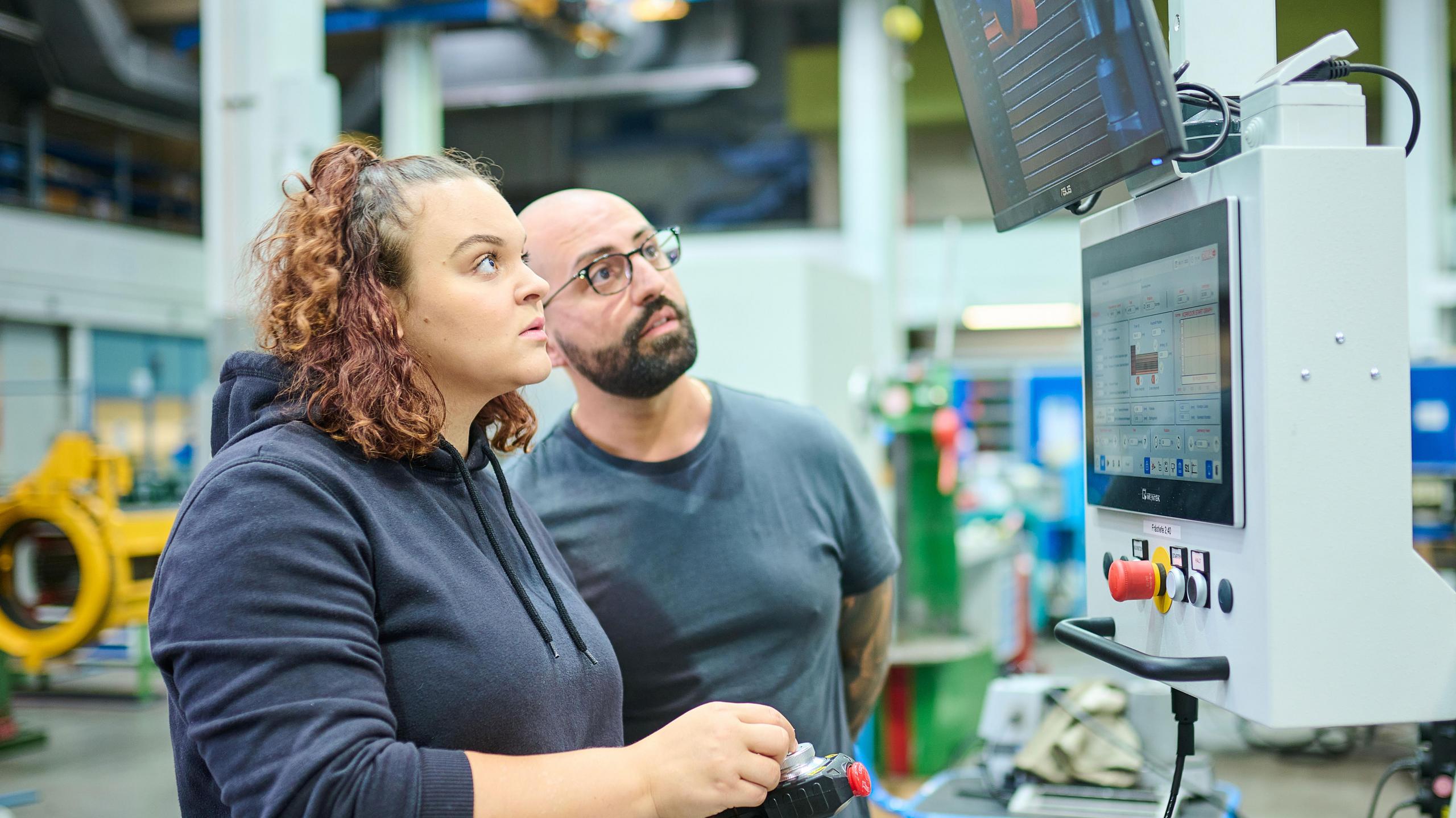 Eine Auszubildende schaut auf einen Elektromotor.
