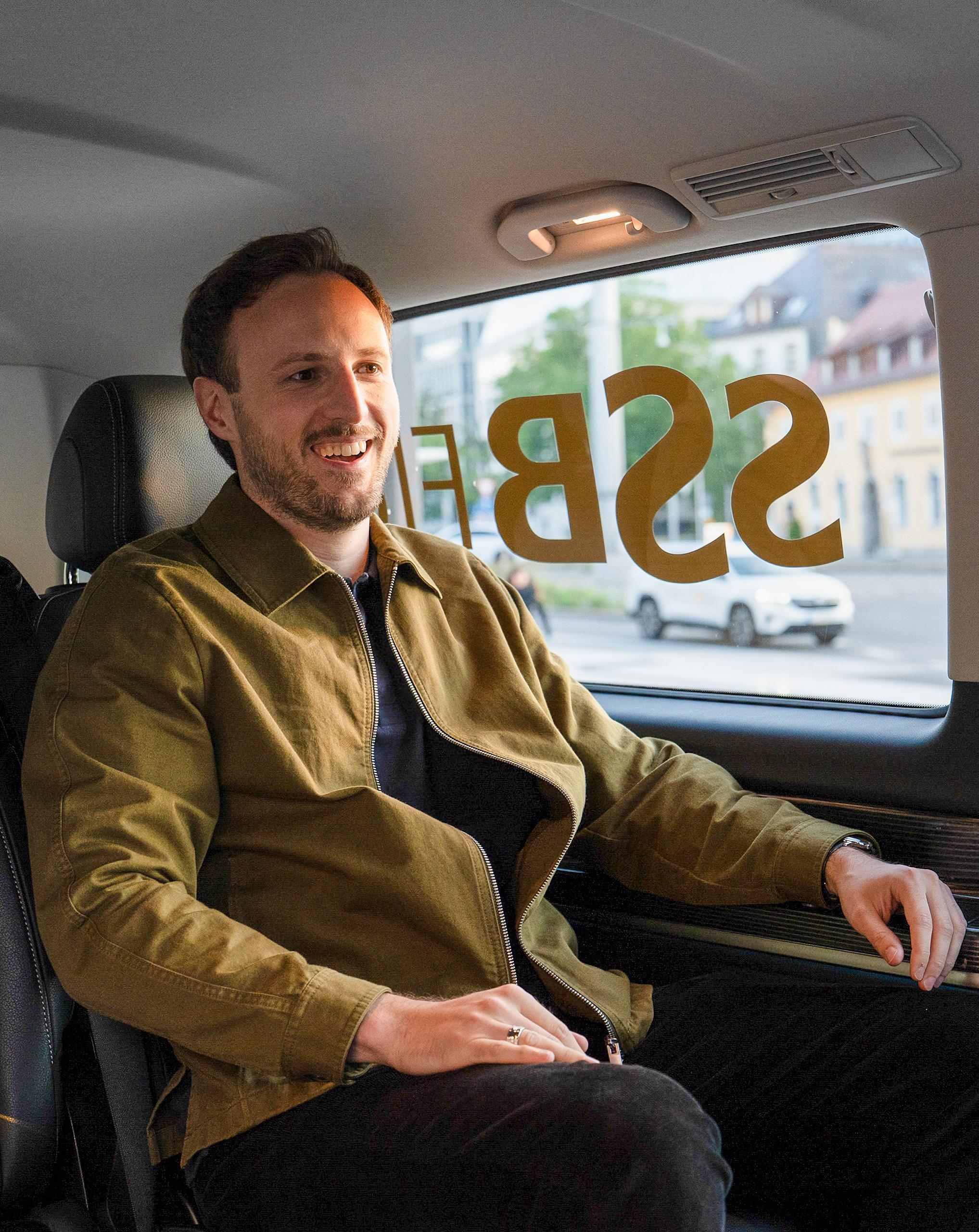 Ein Mann sitzt lächelnd im SSB Flex Fahrzeug.