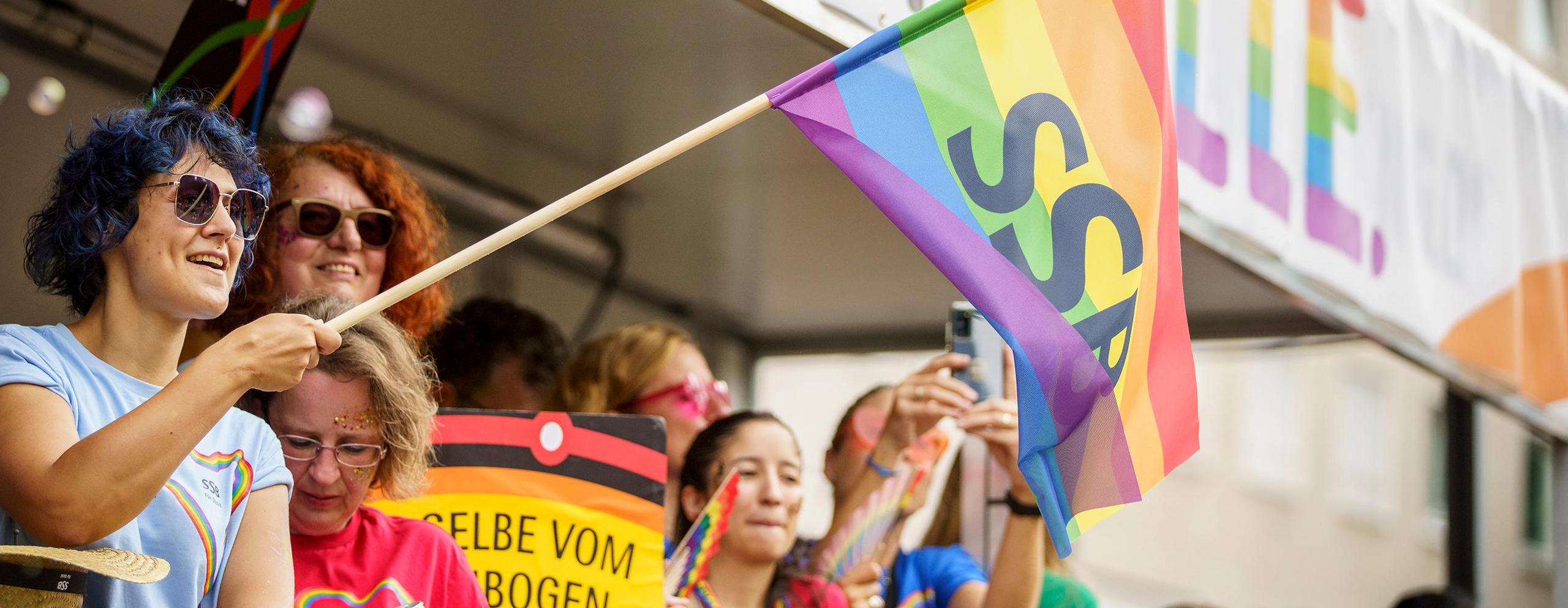 Viele bunt gekleidete SSB-Mitarbeitende feiern auf dem Christopher Street Day.