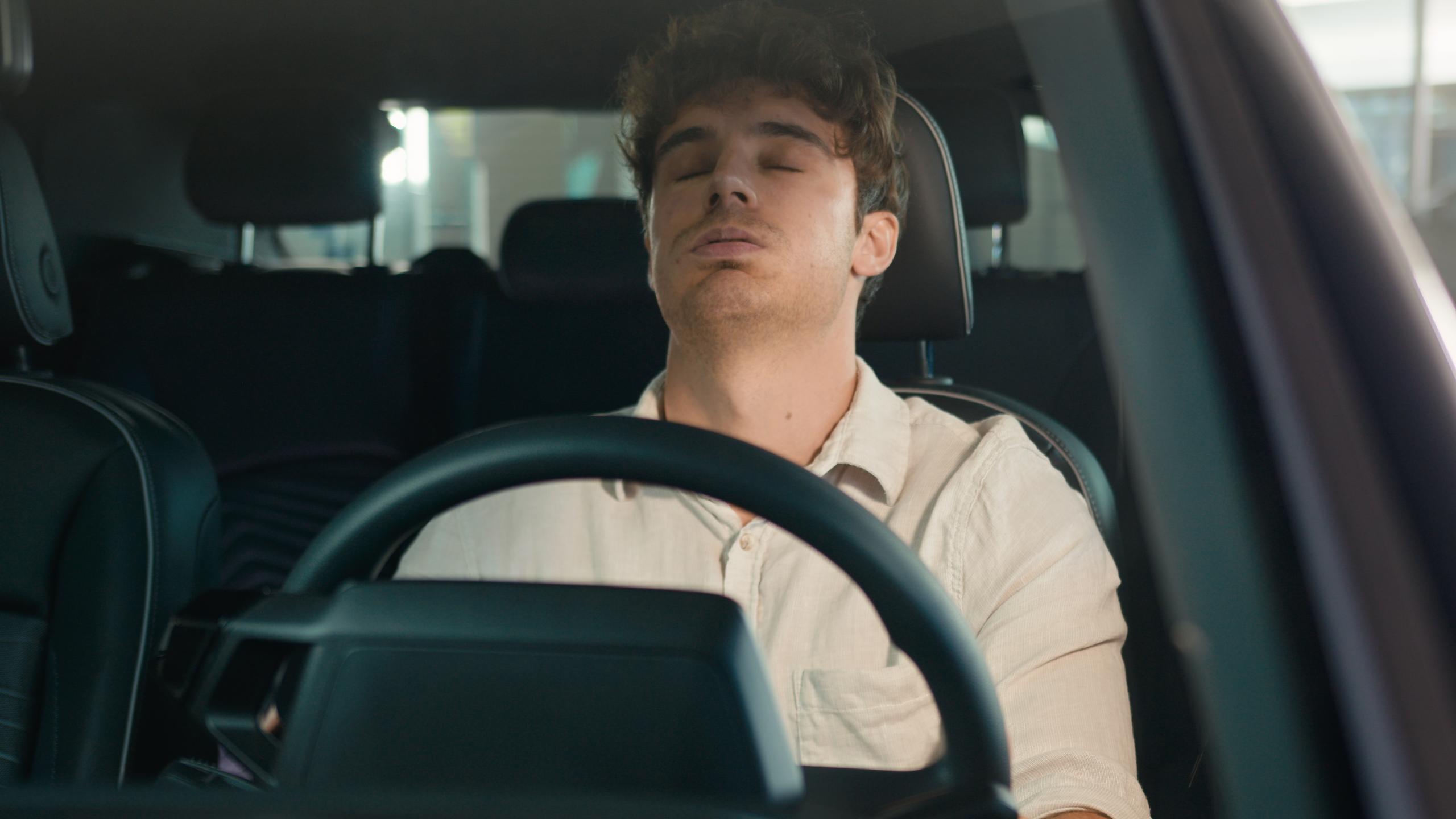 Ein gestresster Mann, der hinter dem Steuer eines Autos sitzt.