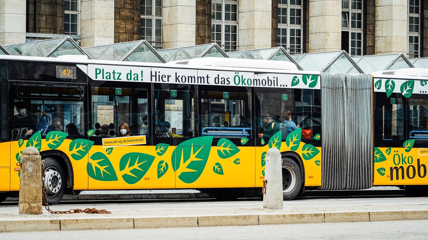 Ein Bus mit grünen Blättern als Beklebung.