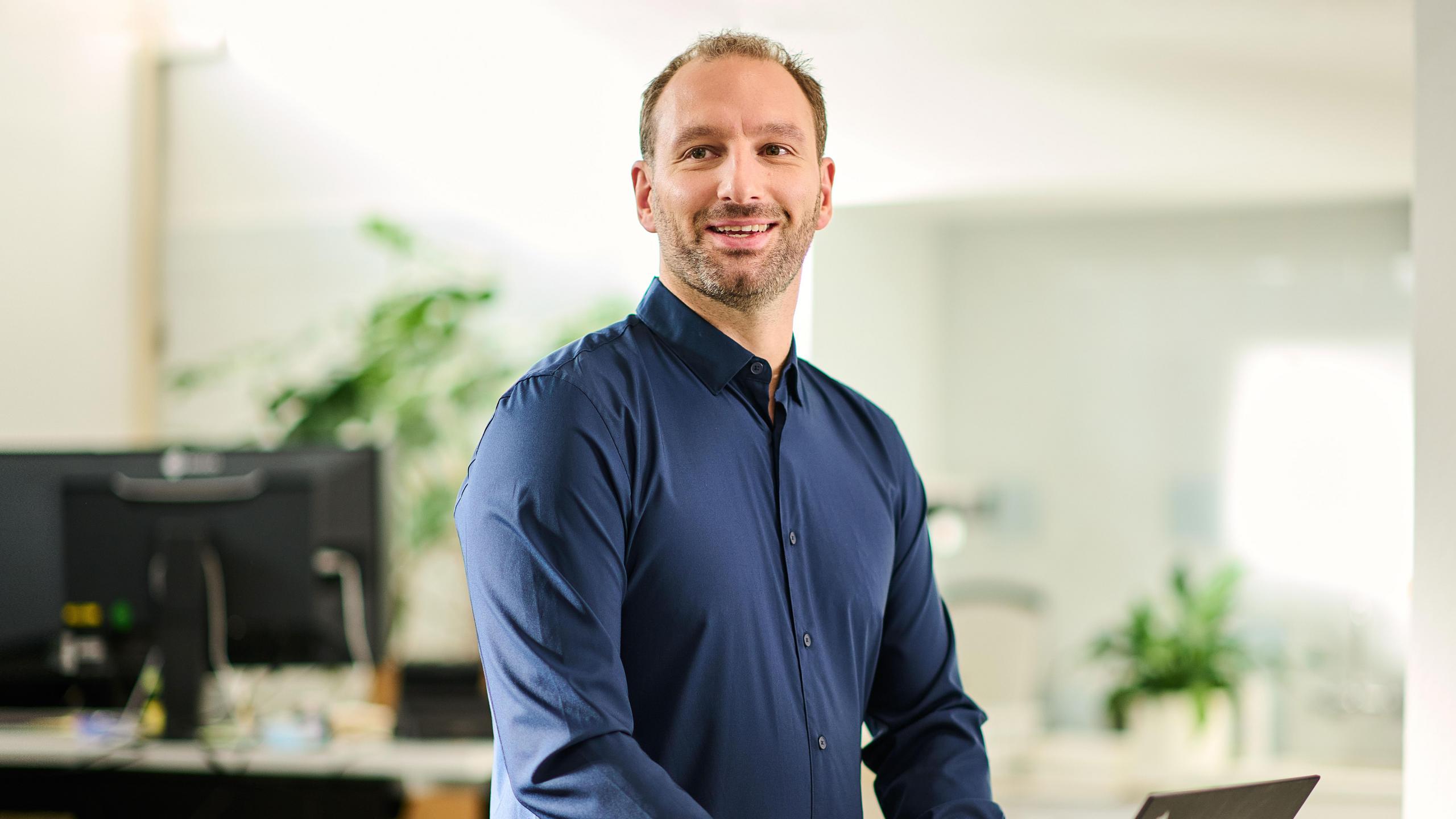 Ein Mann mittleren Alters schreibt auf seiner Notebook-Tastatur.