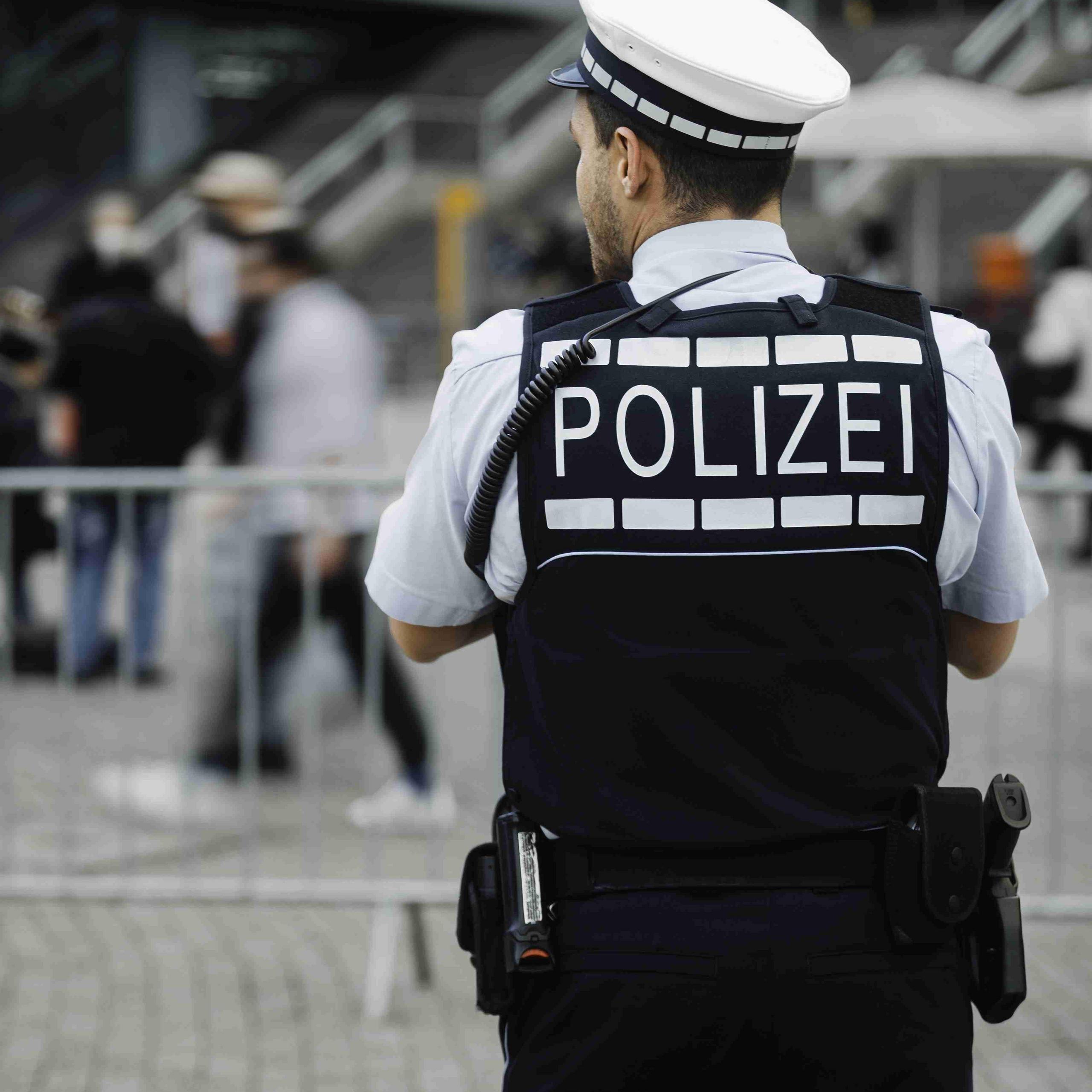 Ein Polizist steht auf einem Platz.