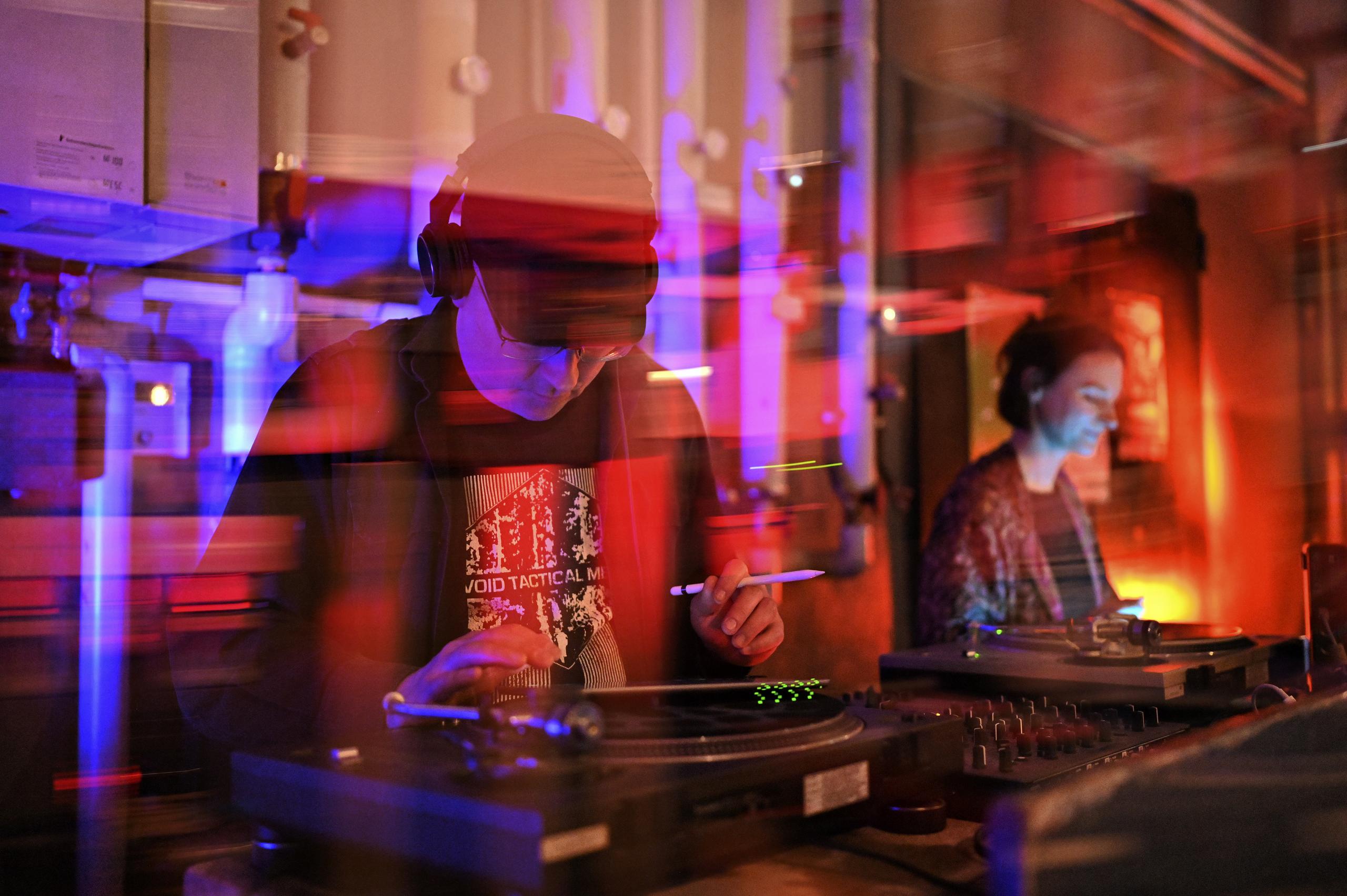 Ein DJ steht am Mischpult.