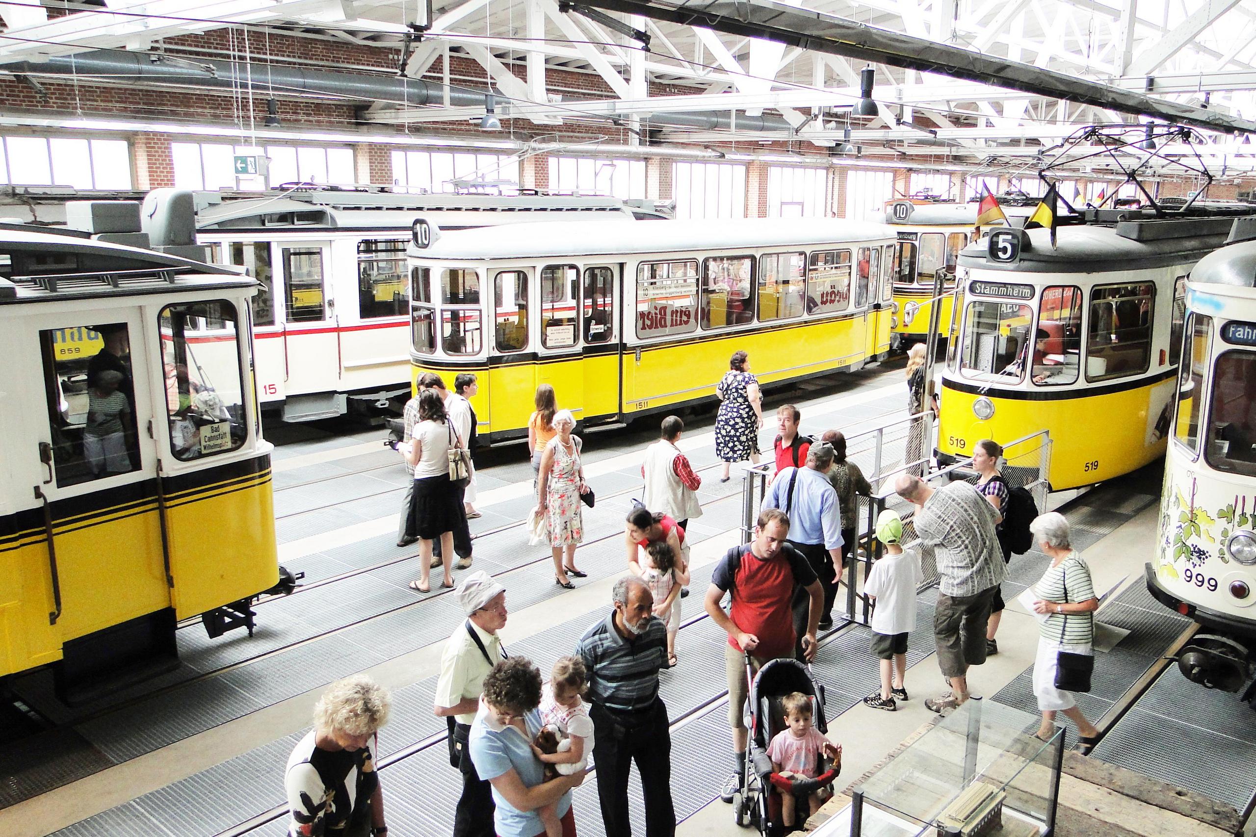 Gäste schauen sich die Straßenbahnexponate im Museum an.
