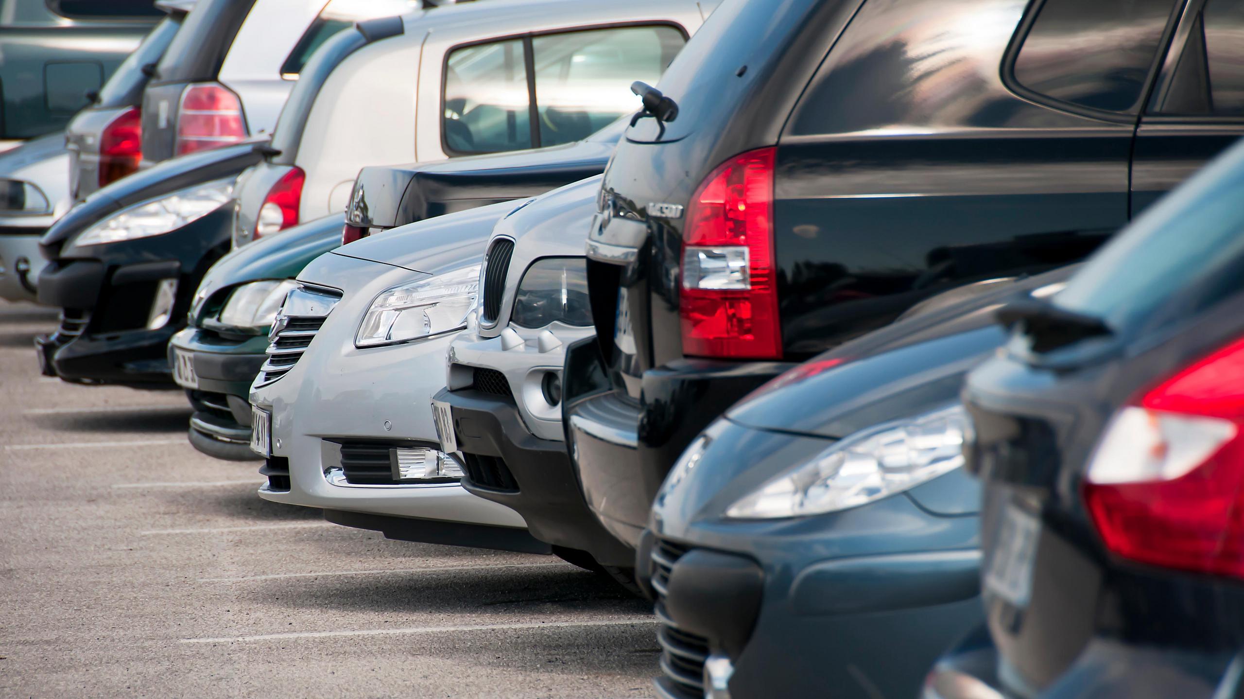 Ein voller Parkplatz mit Autos in der Seitenansicht.