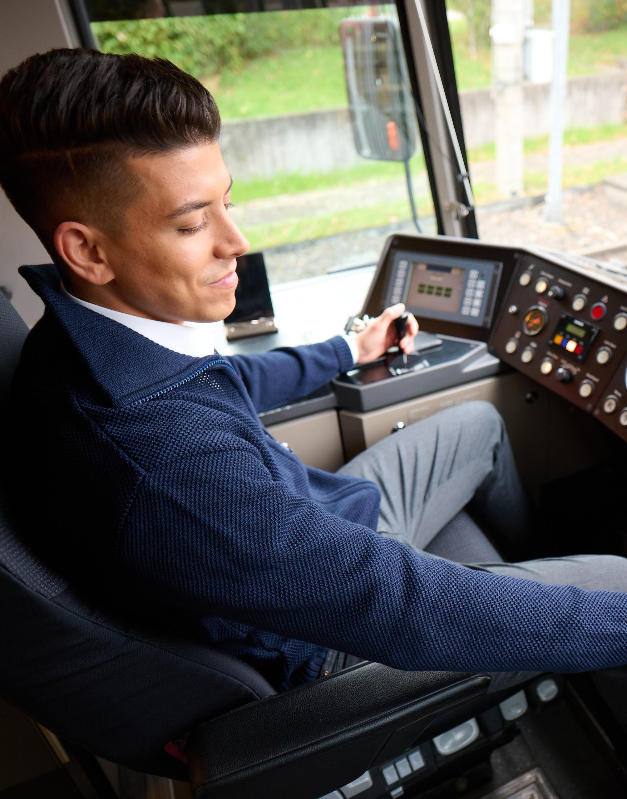Ein Stadtbahnfahrer sitzt im Cockpit und steuert eine Stadtbahn.