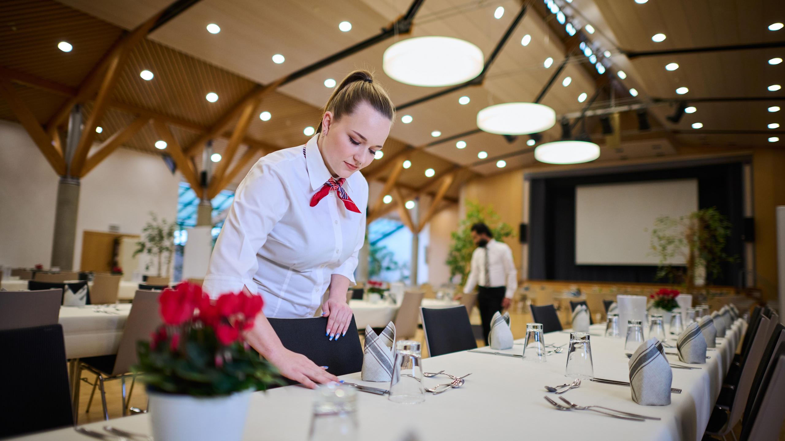 Eine Mitarbeiterin des Waldauparks deckt einen Tisch.