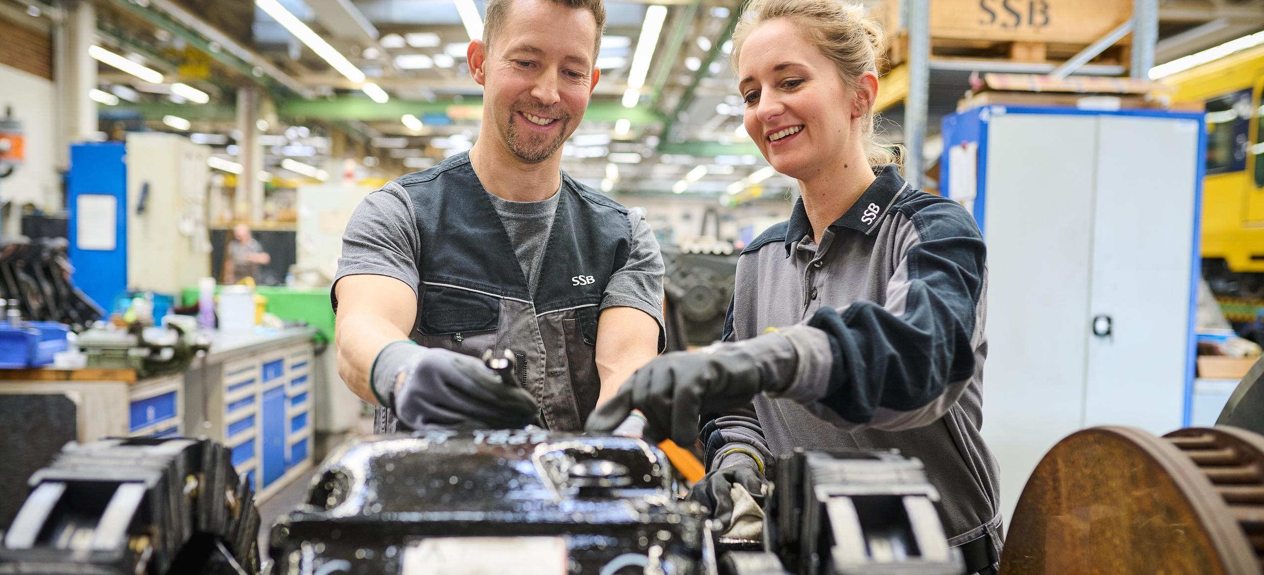 Zwei Werkstattmitarbeiter prüfen ein Fahrgestell.