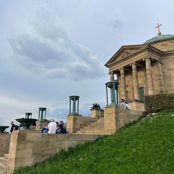 Menschen sitzen auf den Stufen vor der Grabkapelle.