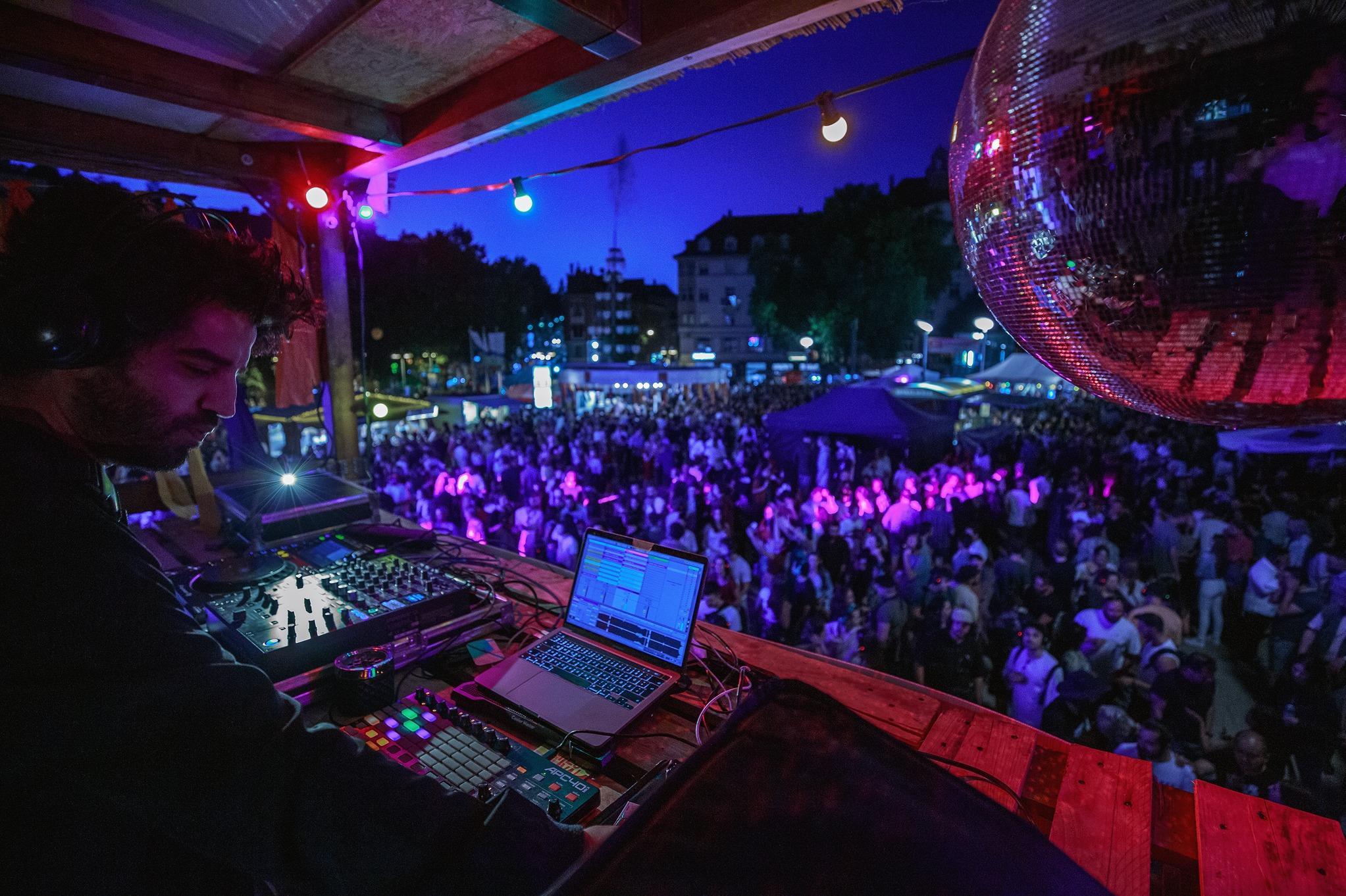 Ein DJ legt abends beim Marienplatzfest auf.