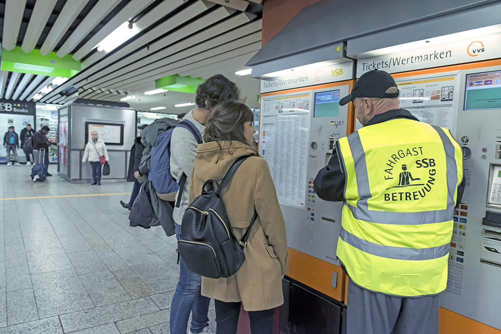 Fahrgastbetreuer erklärt zwei Kunden den Ticketautomaten