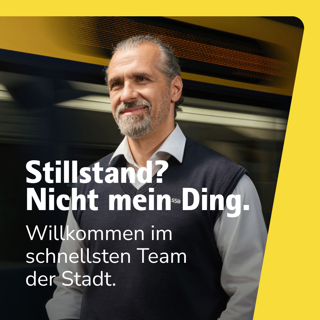 Image-Kampagne Stillstand Ein lächelnder Fahrer steht vor einer vorbeifahrenden Stadtbahn.
