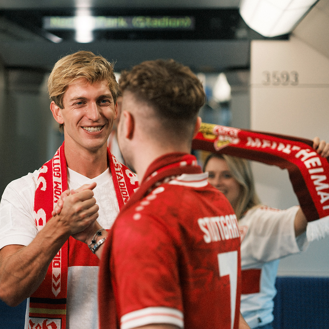 Fans des VfB Stuttgart stehen jubelnd in einer Stadtbahn.