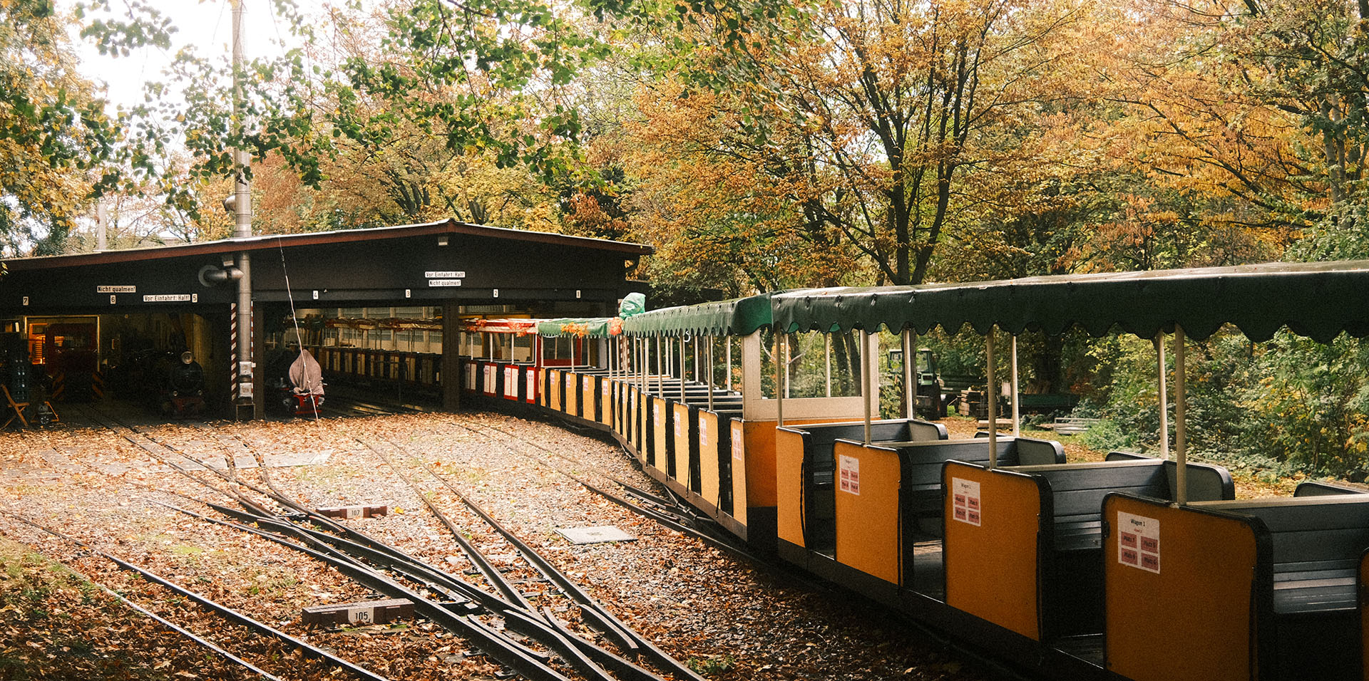 An einem schönen Herbsttag steht eine Lok der Killesbergbahn vor dem Lokschuppen.